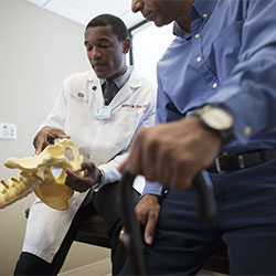 Dr. Milton showing spine model to patient.