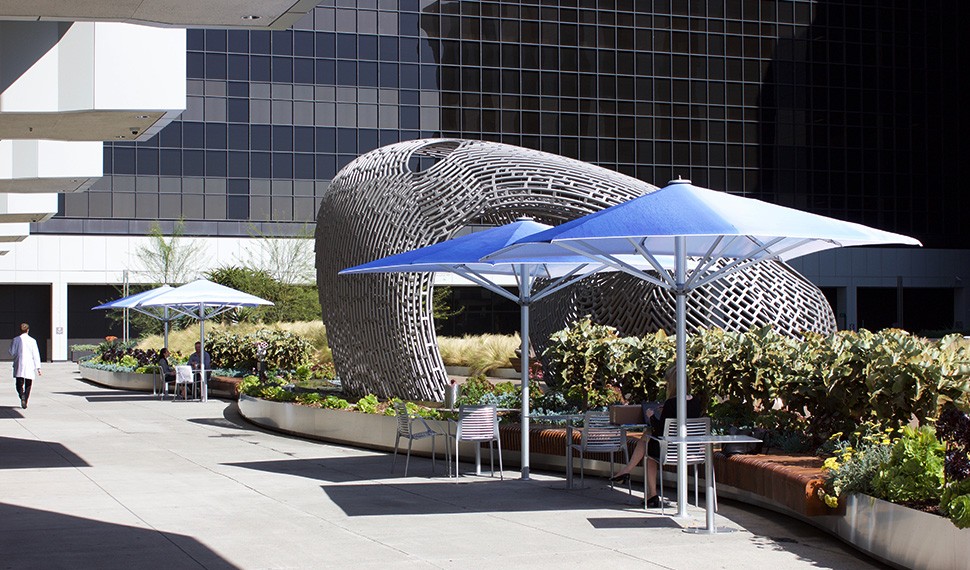 The wave-form steel sculpture created by Ball Nogues Studio complements the ocean theme of artist John Baldessari's umbrellas.