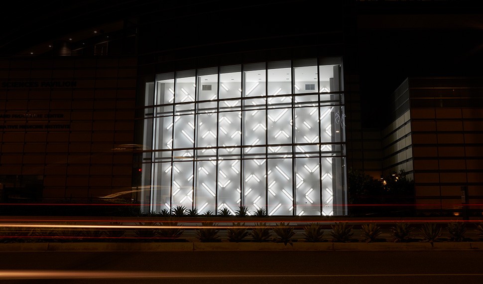 The light installation's grid contains 124 angled fluorescent tubes that create a web of brightness and shadow.
