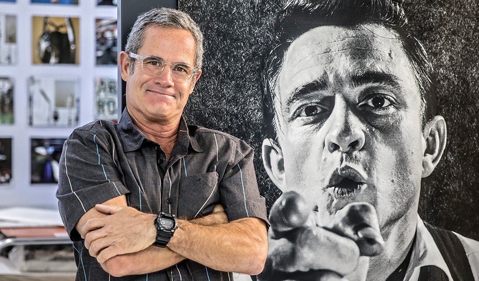 Devik Wiener, son of Leigh Wiener, stands in front of his father's photographic portrait of singer Johnny Cash.
