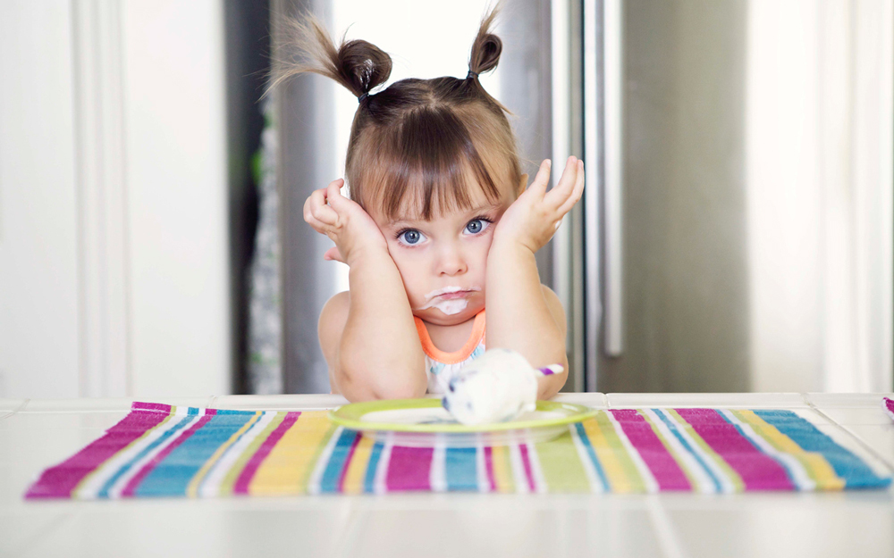 A little girl with frosting on her mouth