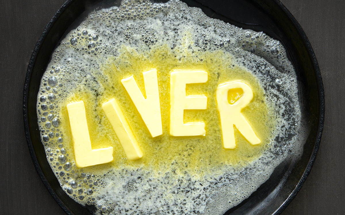 Butter spelling out liver melting in a cast iron pan.