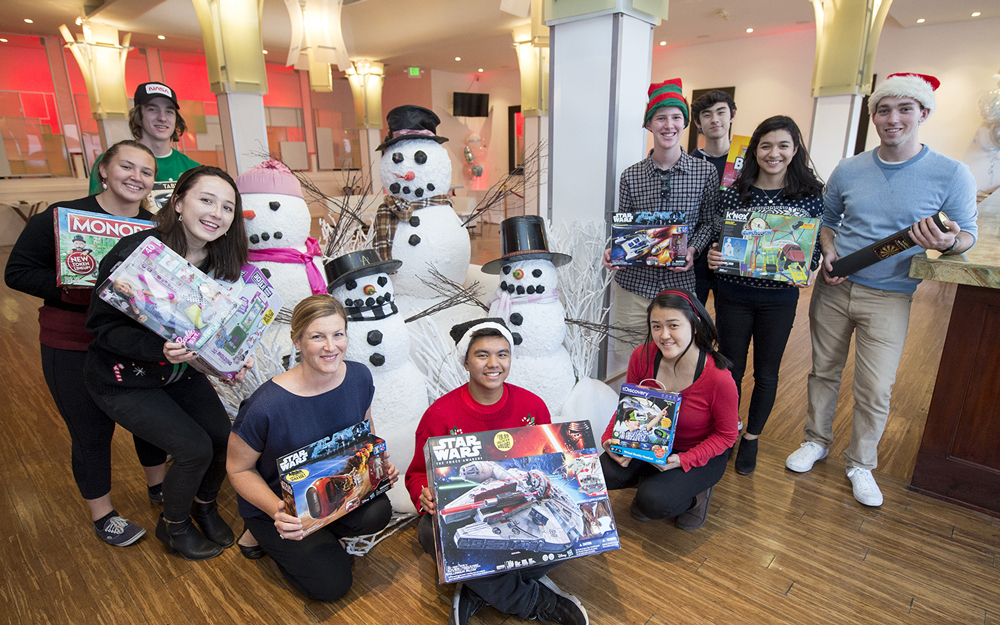 El Segundo High School students holding Christmas presents at the Cedars-Sinai holiday party.