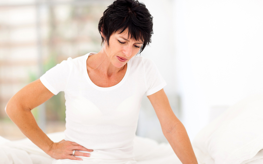 Woman holding her side in pain.