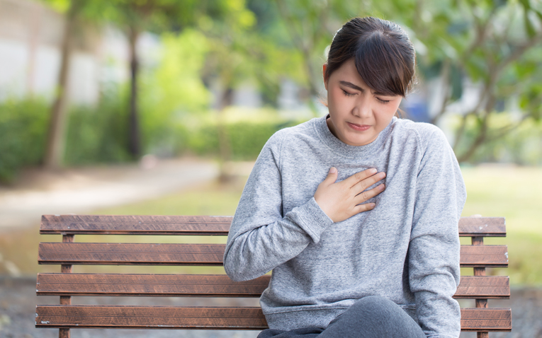 Woman holding her chest in pain