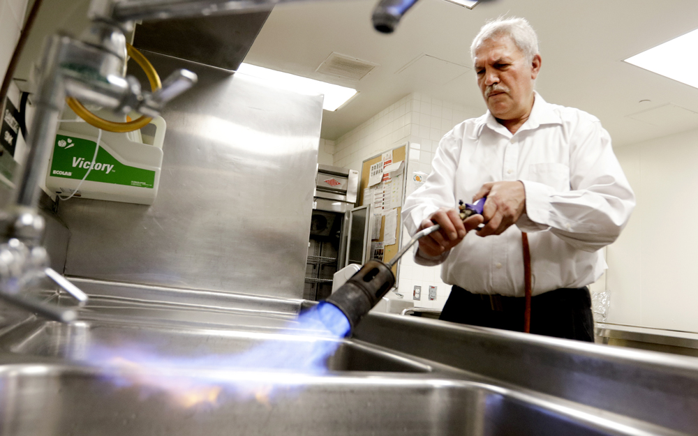 Benjamin Saghizadeh a Mashgiach from the Rabbinical Council of California uses a propane blowtorch to cleanse the metal kitchen sink in preparation for Passover.  In Preparation for Passover, the kosher kitchen cleans all appliances and metal surfaces with fire or hot water.