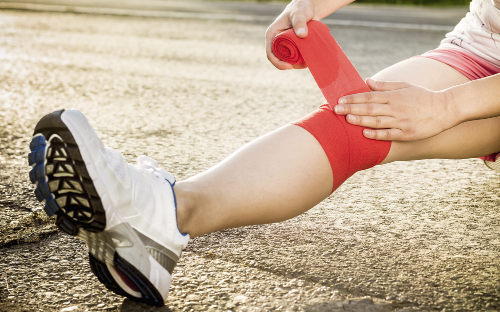 A runner with a torn meniscus wraps an injured knee.
