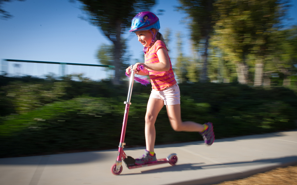 Lara Borda after her heart procedure playing in the park on a scooter.