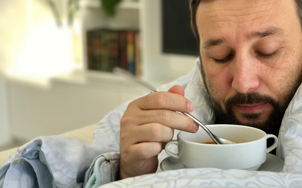 A man eating a bowl of hot soup.