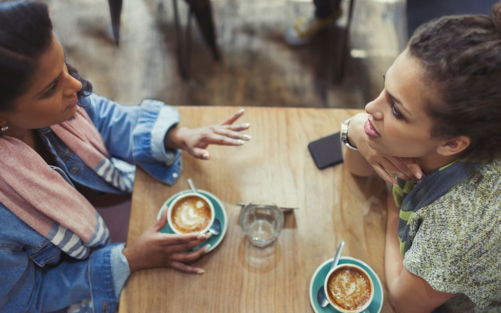 Two people talking and drinking coffee