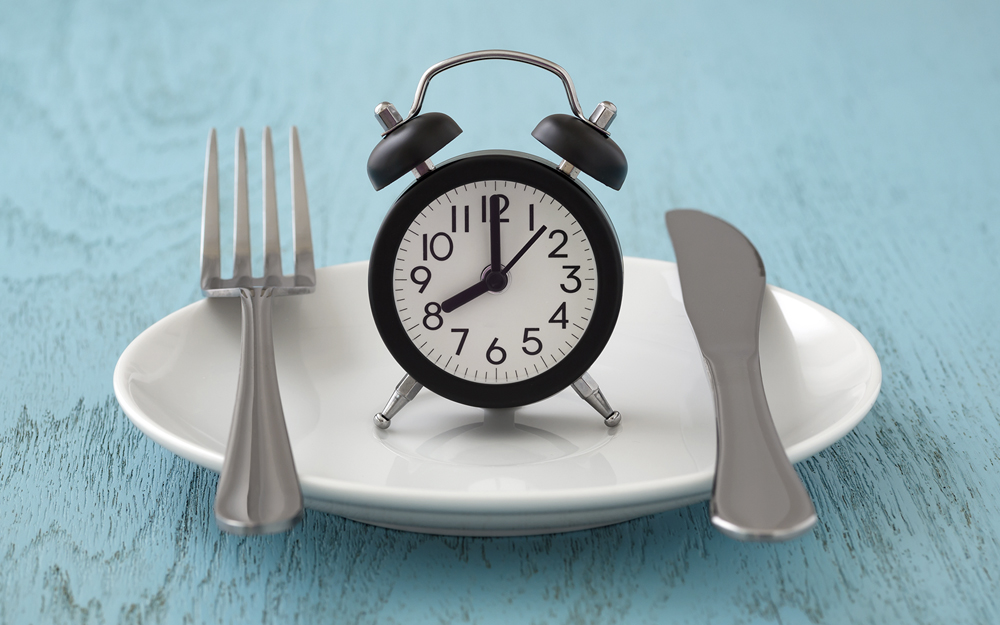 Clock on plate with fork and knife.