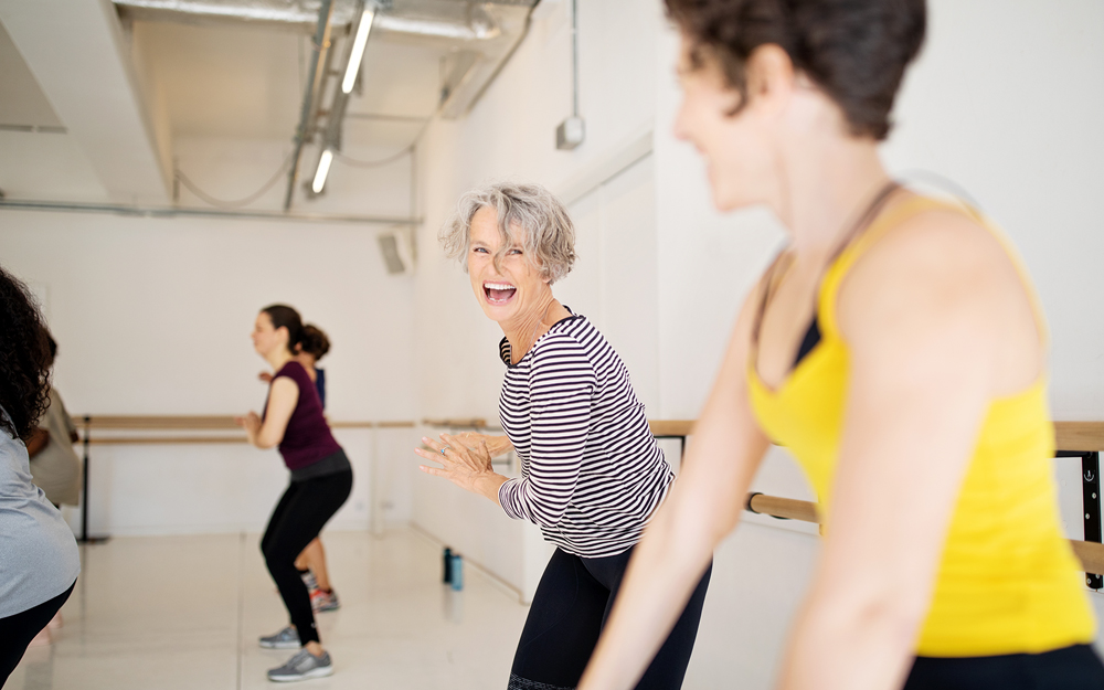 A group of women exercising in a gym in away safe from the effects of high blood pressure.