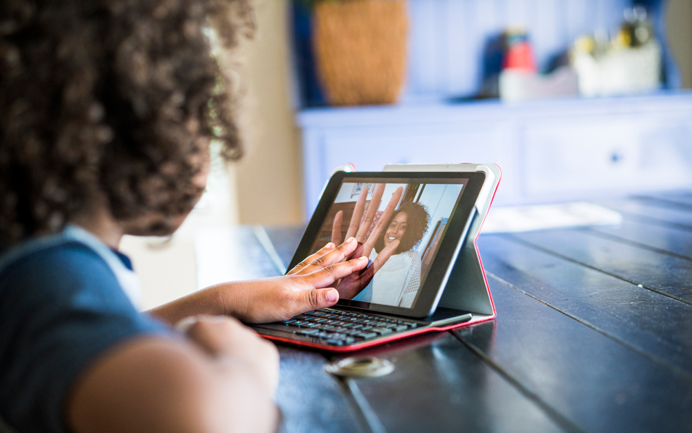 A young woman connects with family over the internet during the COVID-19 pandemic.