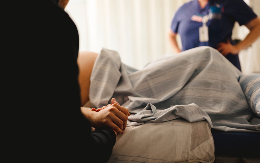 A midwife doula sits with a woman about to give birth.