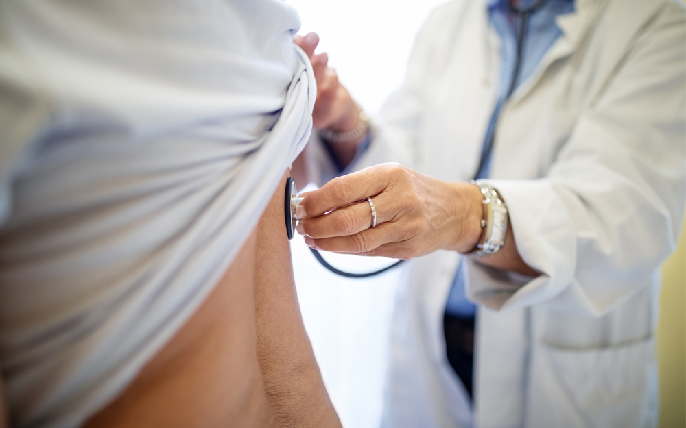 A doctors checks a patient after a  mitral valve procedure.