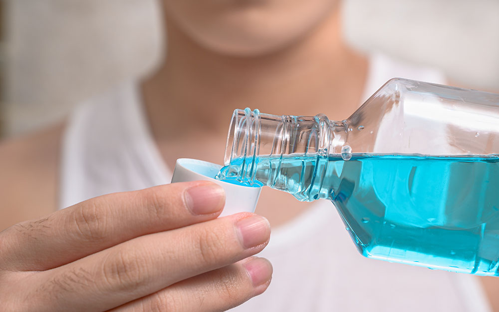 Man pouring mouth wash to prevent COVID-19 infections.