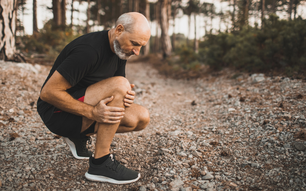 An older man with knee and hip pain after exercising.