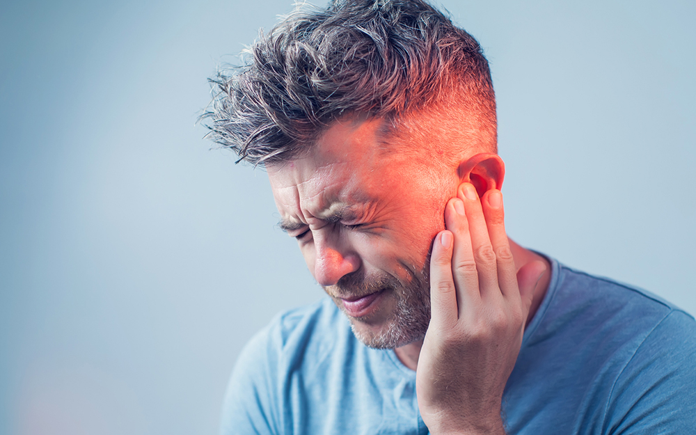 Male having ear pain touching his painful head is.