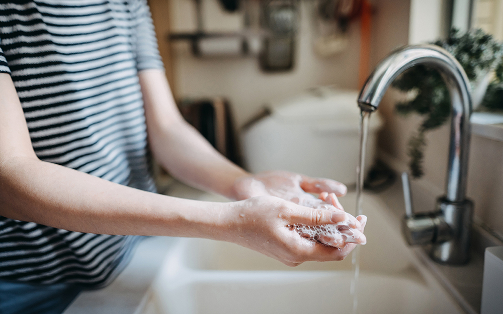 Woman washing her hands at a sink.
