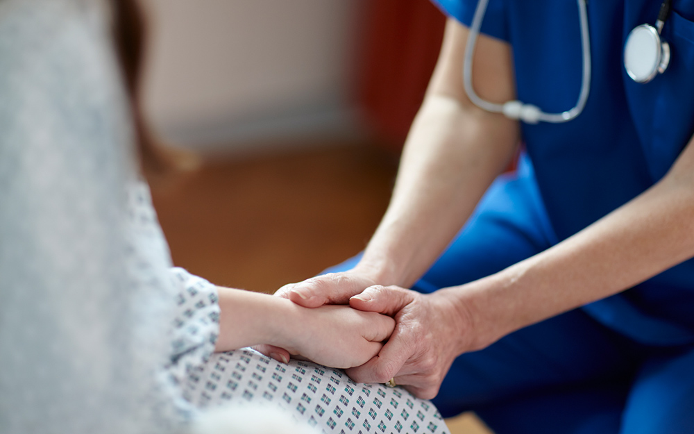 A nurse comforting a patient with a PCOS diagnosis.