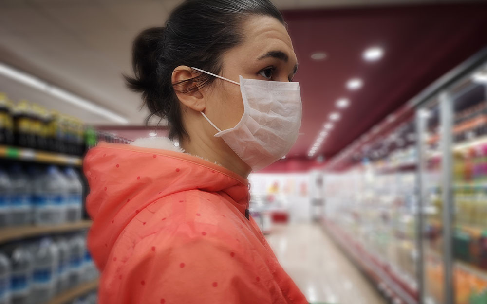 Women with a mask in a supermarket.