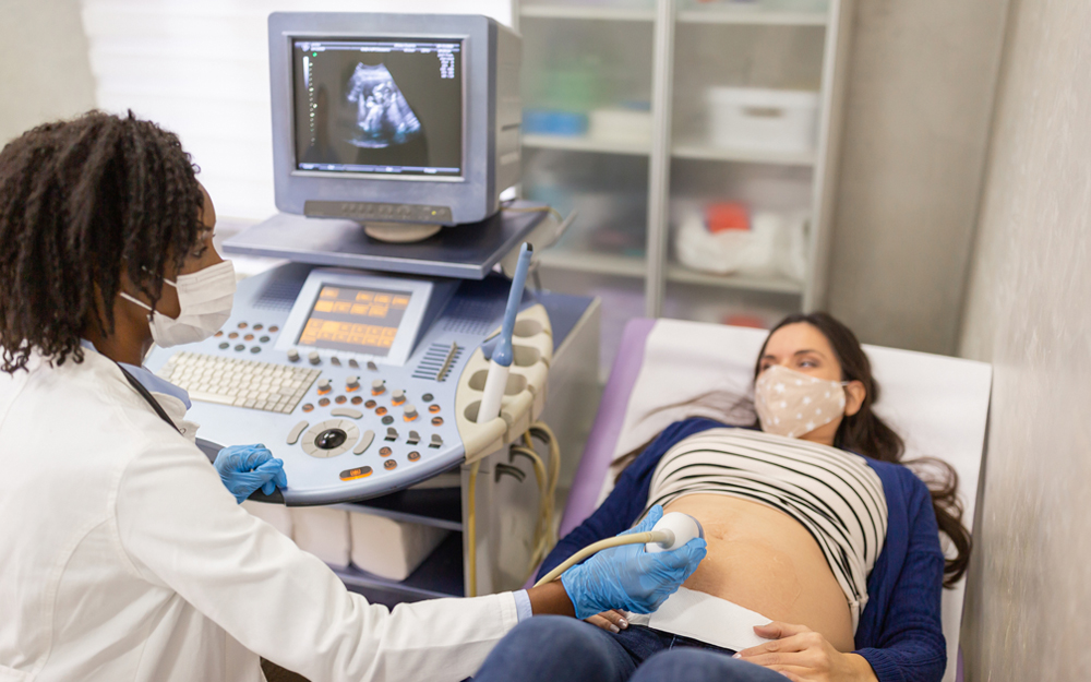 A pregnant woman getting ultrasound from a perinatologist.