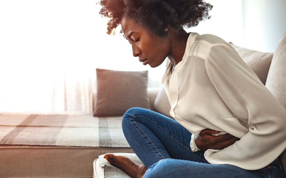 A Black woman experiencing uterine fibroid pain.