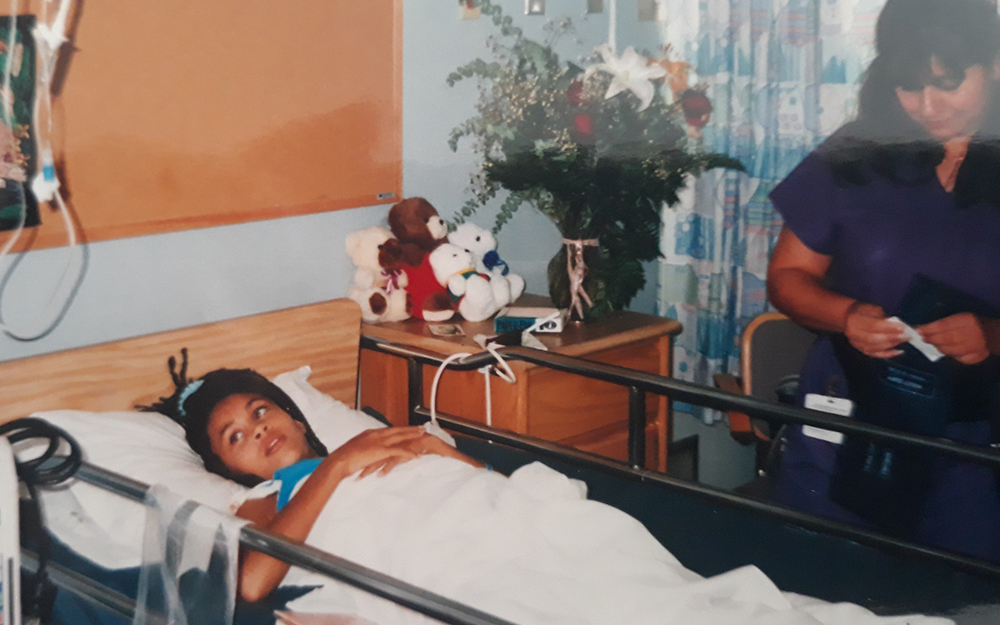 Sandra Gray laying on a hospital bed.