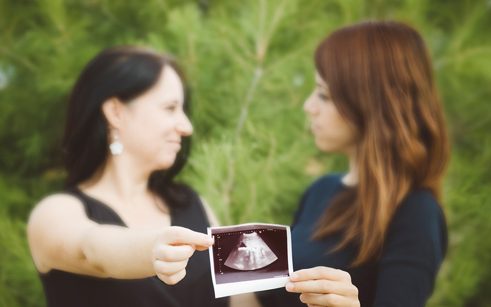Women couple holding ultrasound.