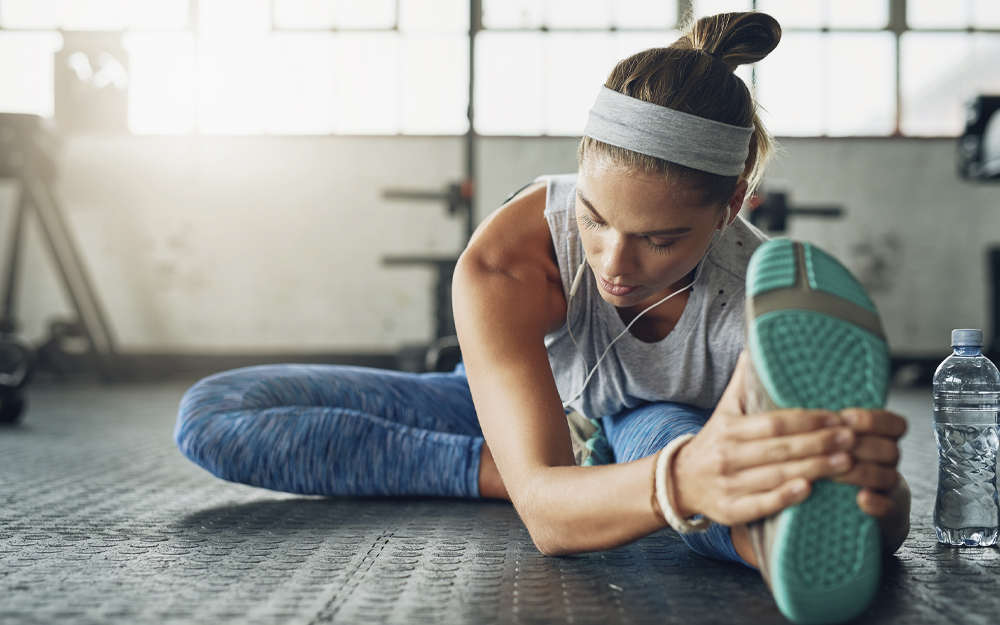 A woman stretching her legs before exercising. 