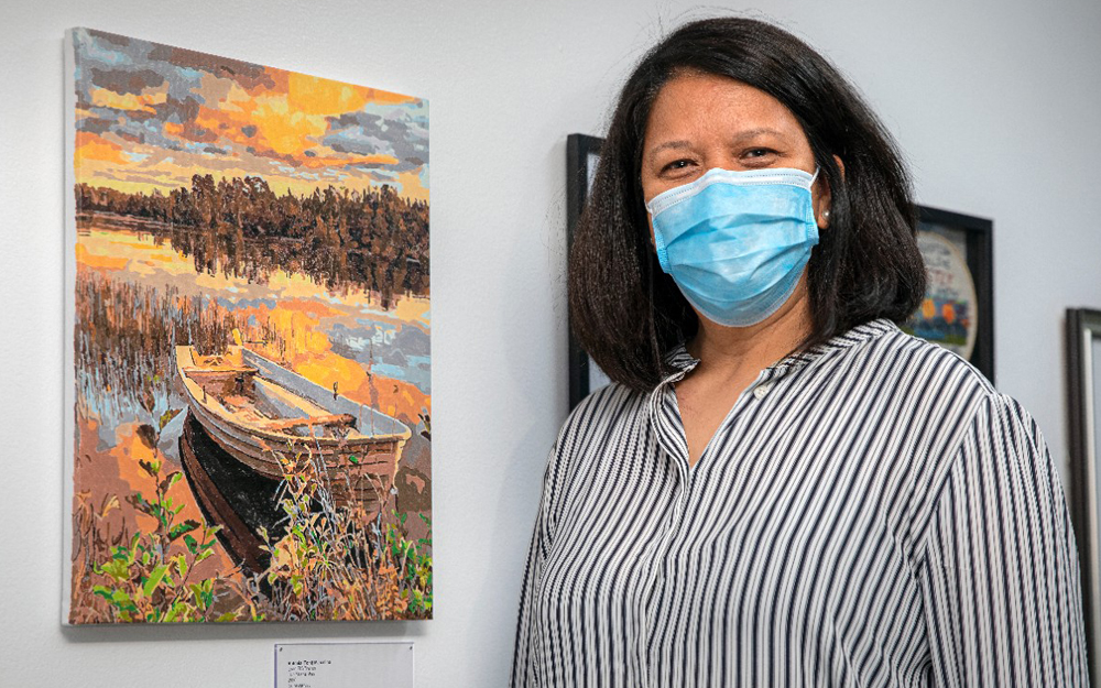 Cedars-Sinai employee posing for a picture with her painting