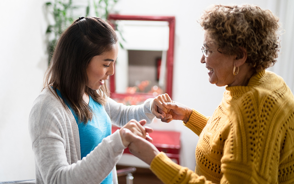 Nurse supporting helping senior patient walking