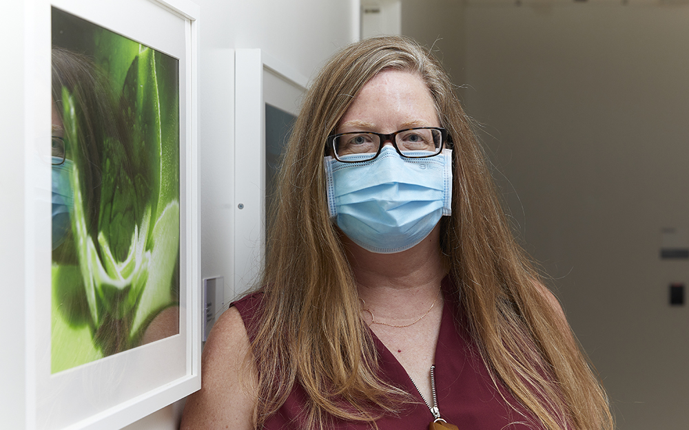 Jessica Meaney standing in front of her daughter, Caitlin's snapshot of a green succulent.