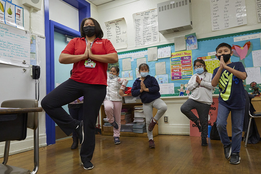 Premere Sessions practicing yoga with the class.