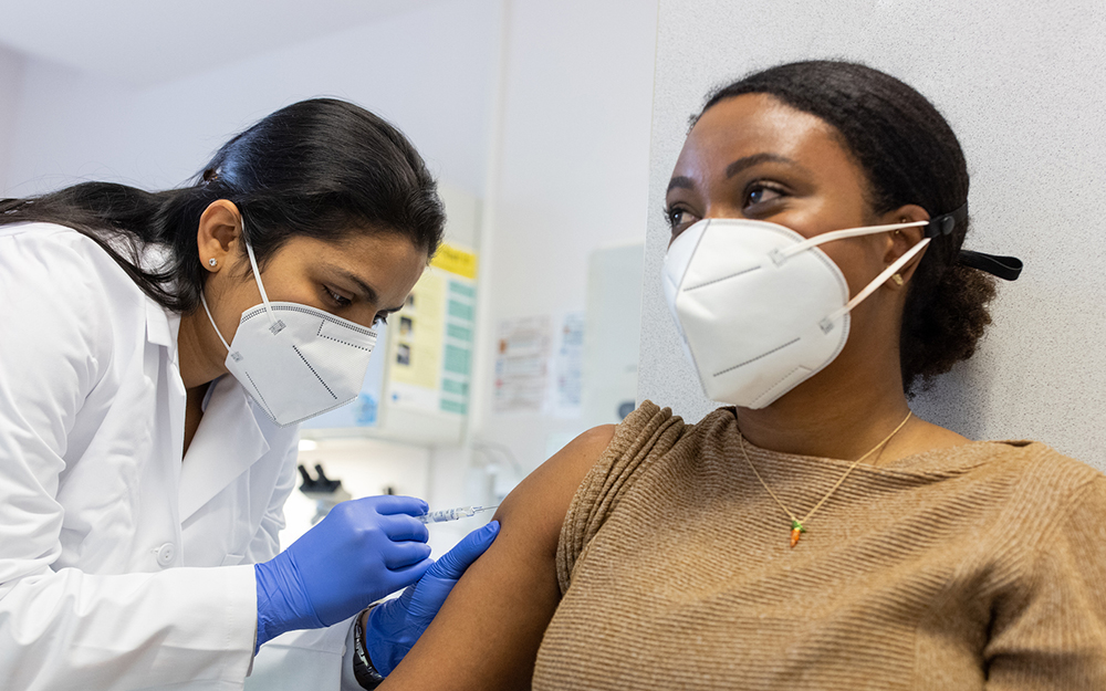 Concentrated woman doctor vaccinating a young woman