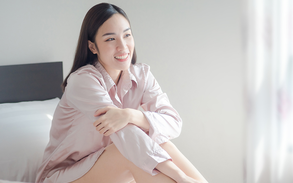 Woman sitting on her bed.