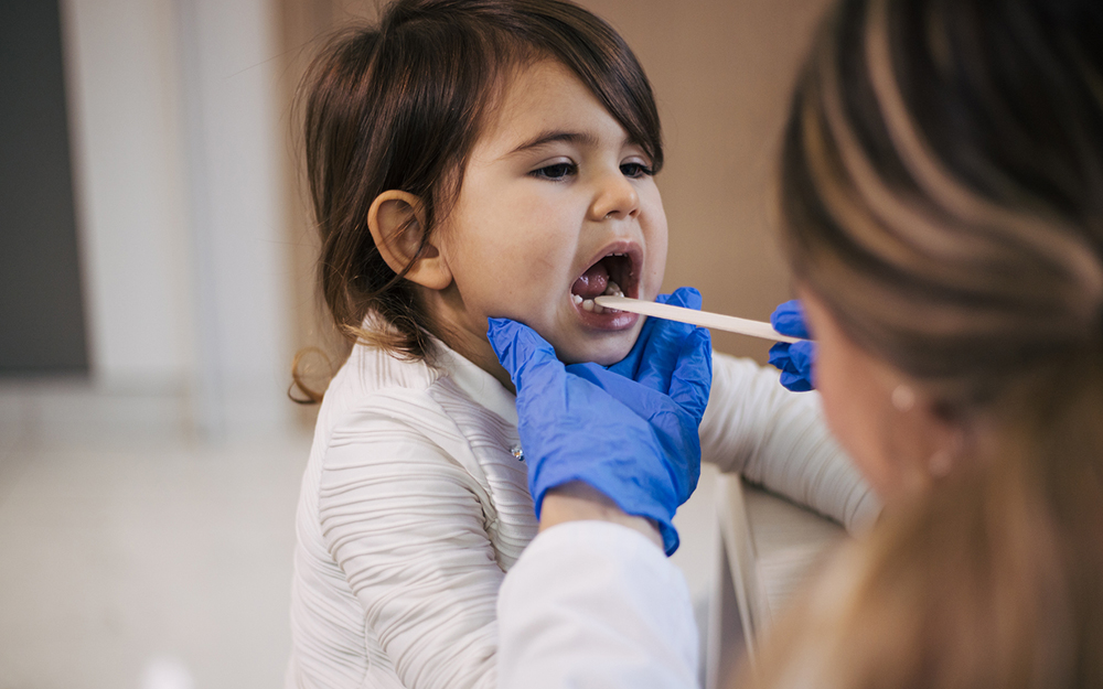 Pediatrician's Office, child getting their tonsils checked.