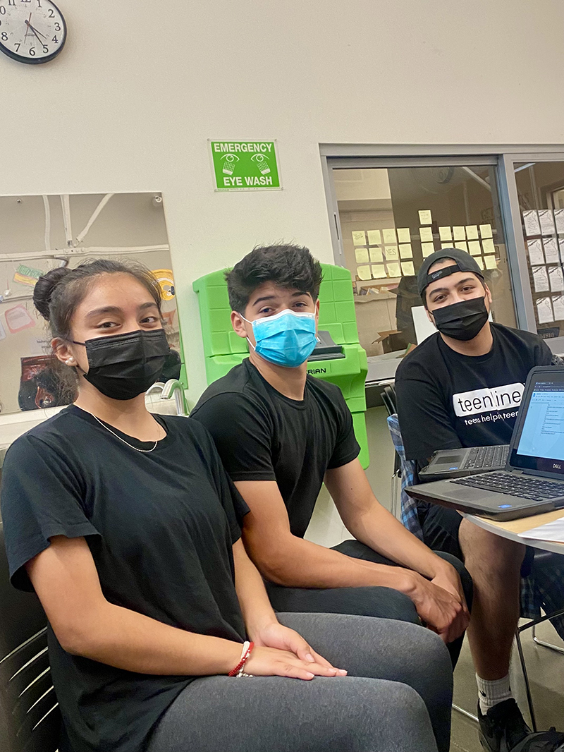 Three Teen line volunteers in the classroom.