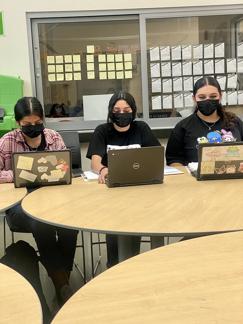 Three teen line volunteers working on laptops helping callers
