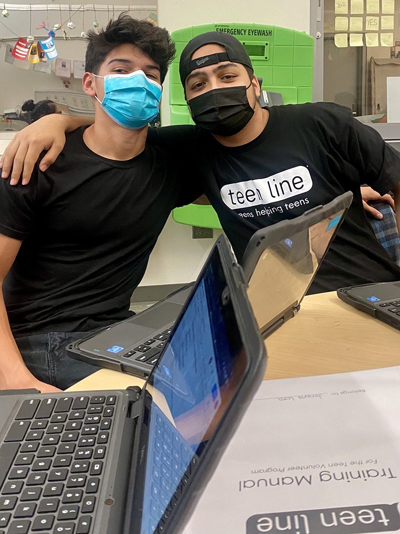 Two Teen line volunteers working on their laptops.