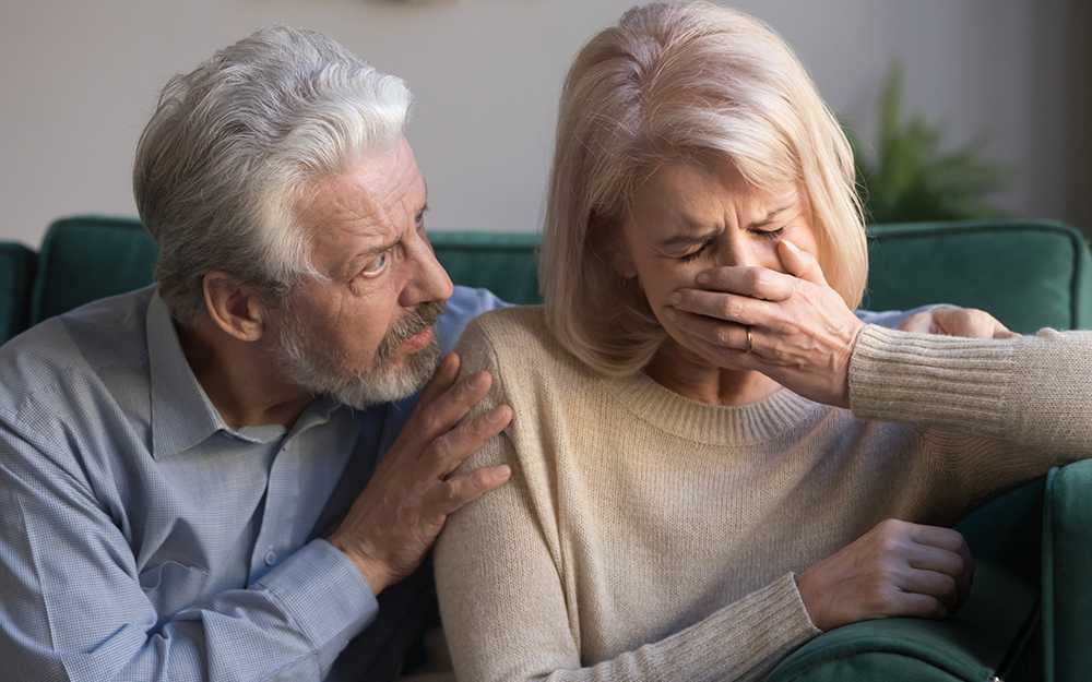 Worried kind senior husband comforting crying mature wife giving compassion.