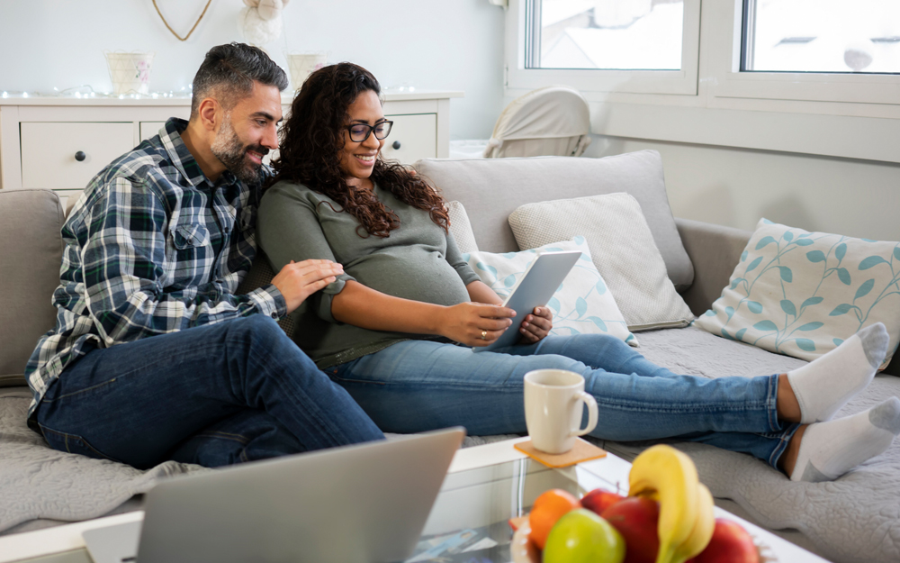 Un esposo y una esposa en casa emocionados por tener un bebé.