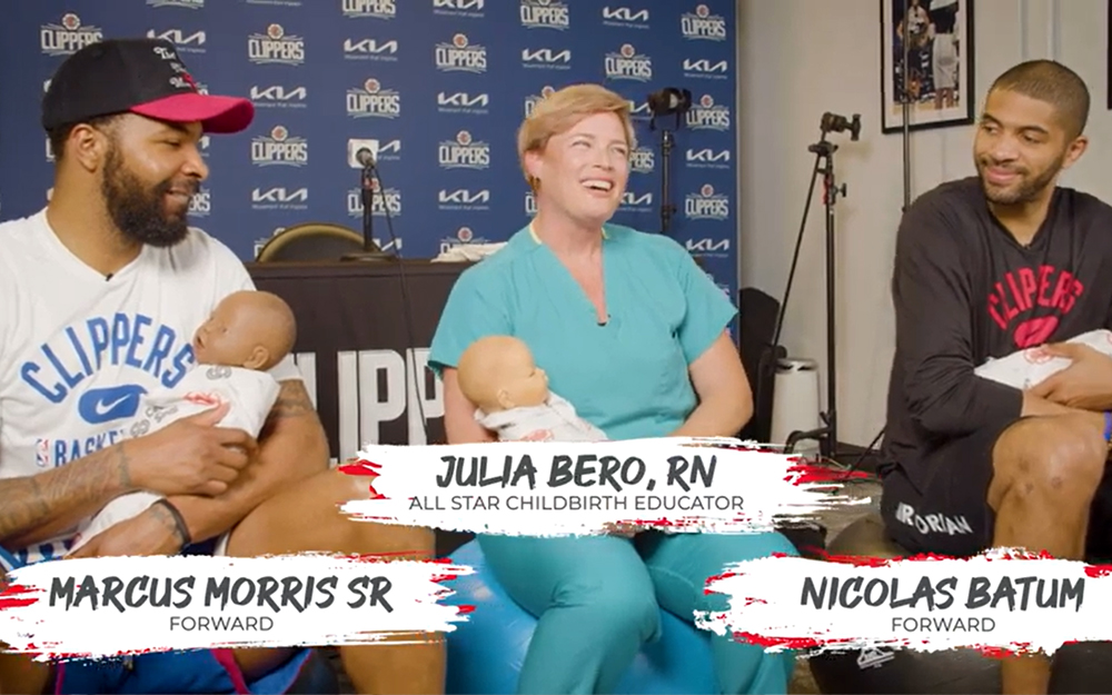 LA Clippers Forwards Marcus Morris Sr. and Nicolas Batum learn baby skills with Cedars-Sinai nurse Julia Bero. 