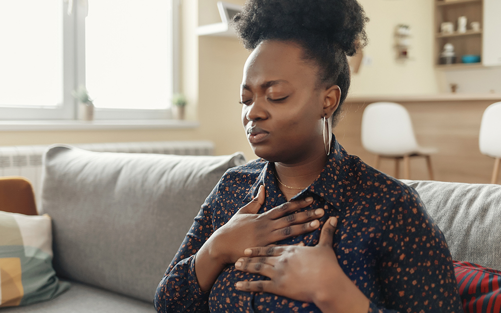 Pressure in the Chest. Close-up Photo of a Stressed Obese African American Woman Who Is Suffering From a Chest Pain and Touching Her Heart Area.
