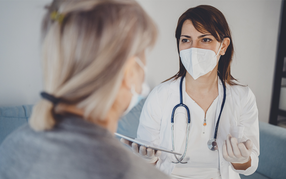 Female doctor consulting with senior patient at home