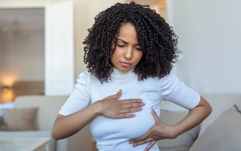 Young African American woman palpating her breast