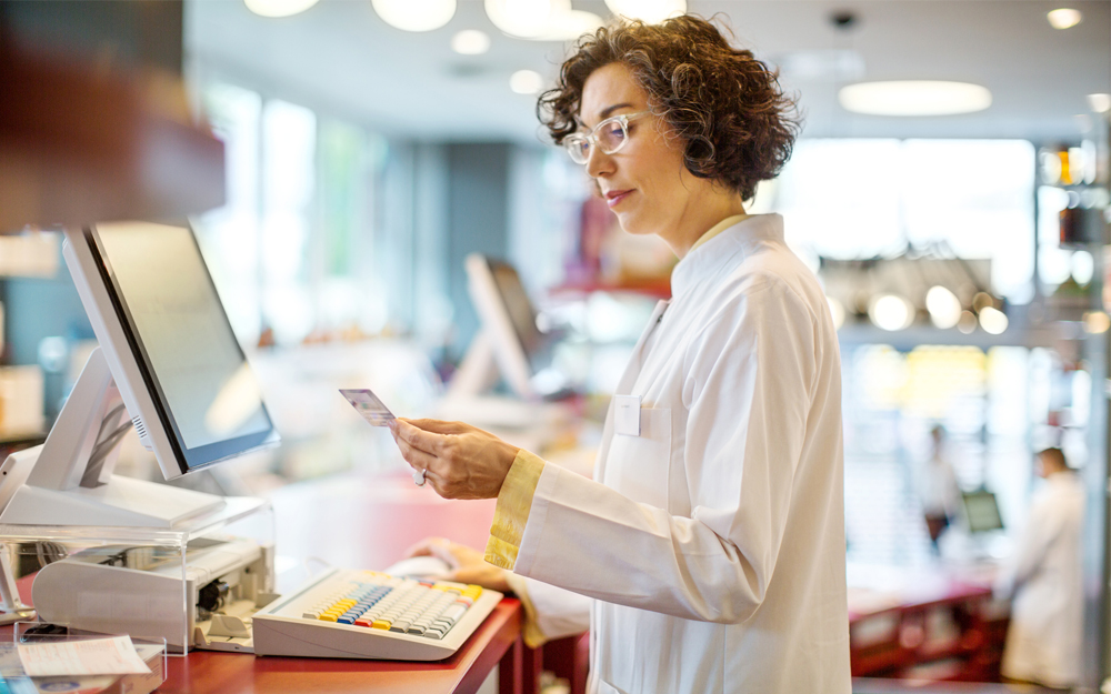 A mature female pharmacist in a hospital preparing to fill a patients prescription.