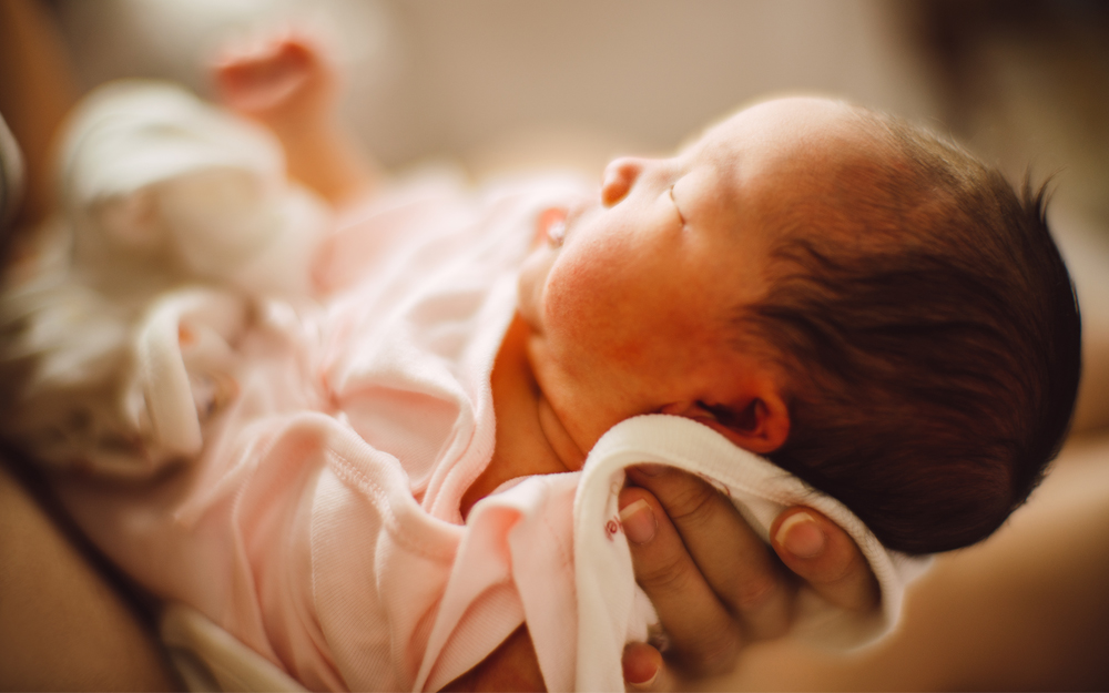 A newborn baby being held.