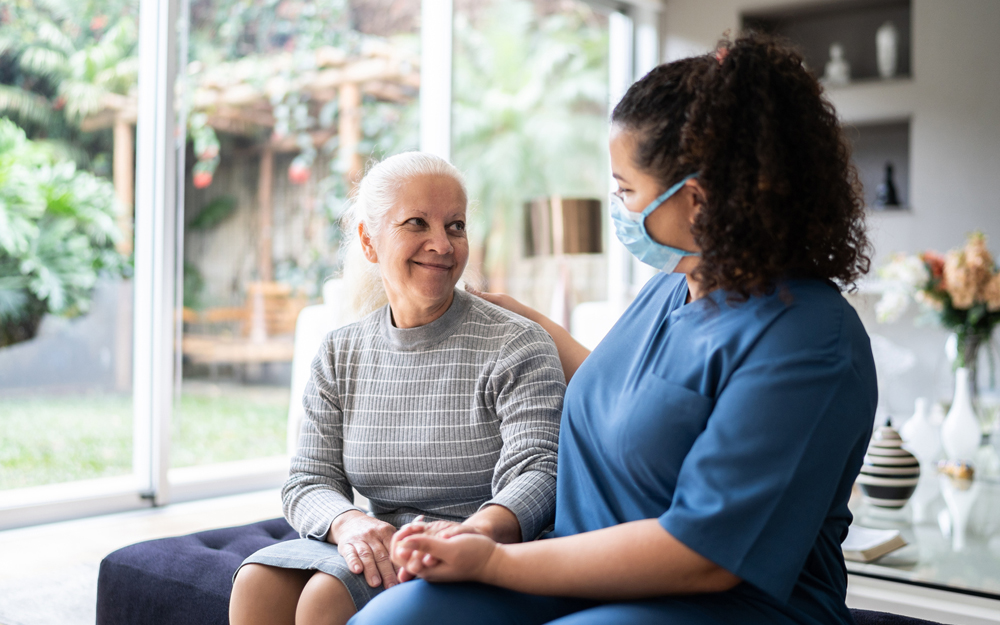 A home nurse aid assisting an elderly woman at home.