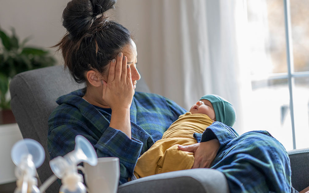 Mother holding baby and staring out the window